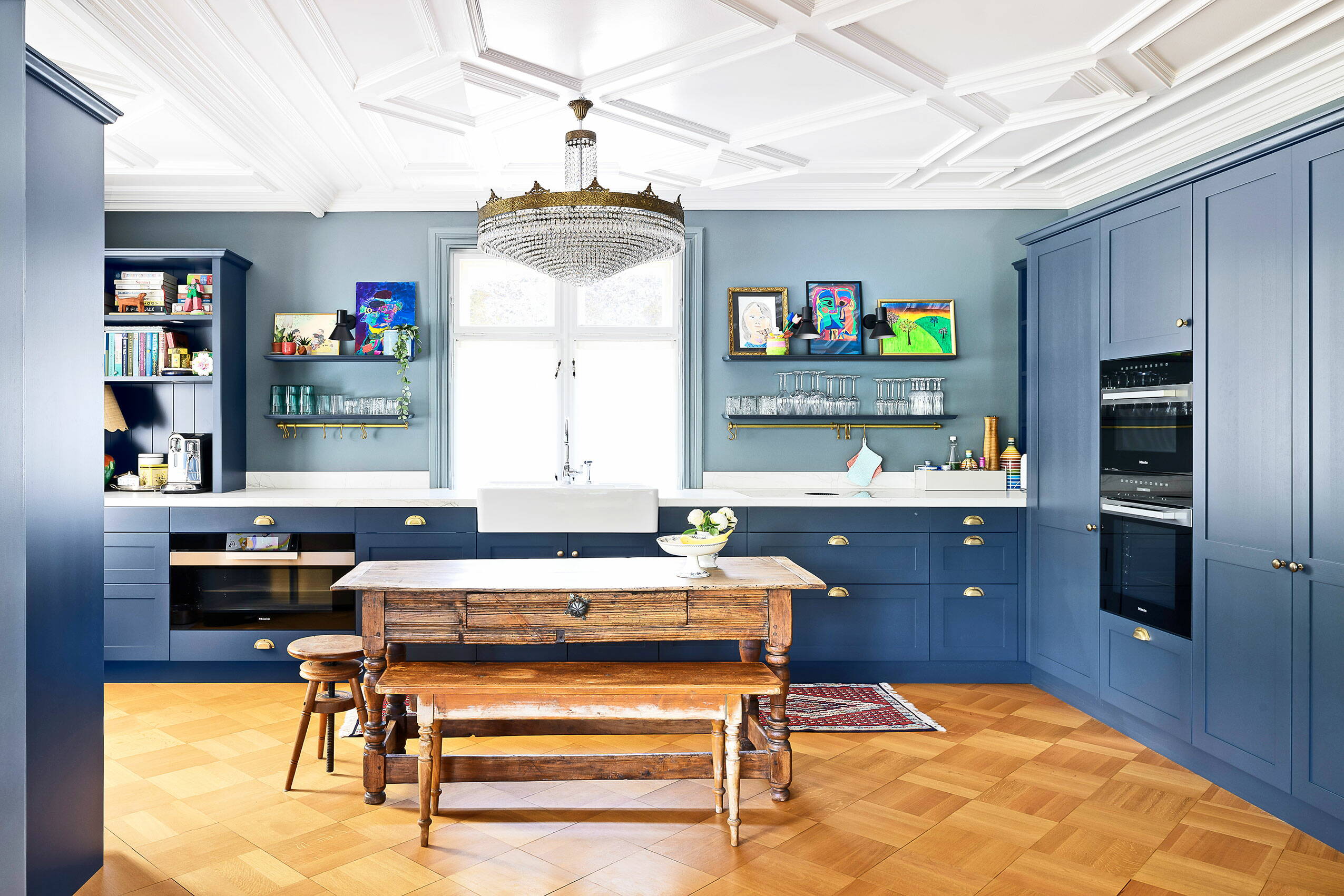 Zoom: Eine modern umgebaute Küche mit Altbaucharme, Oberflächen und Boden in Holz gearbeitet, Stuckaturen und Kronleuchter an der Decke.