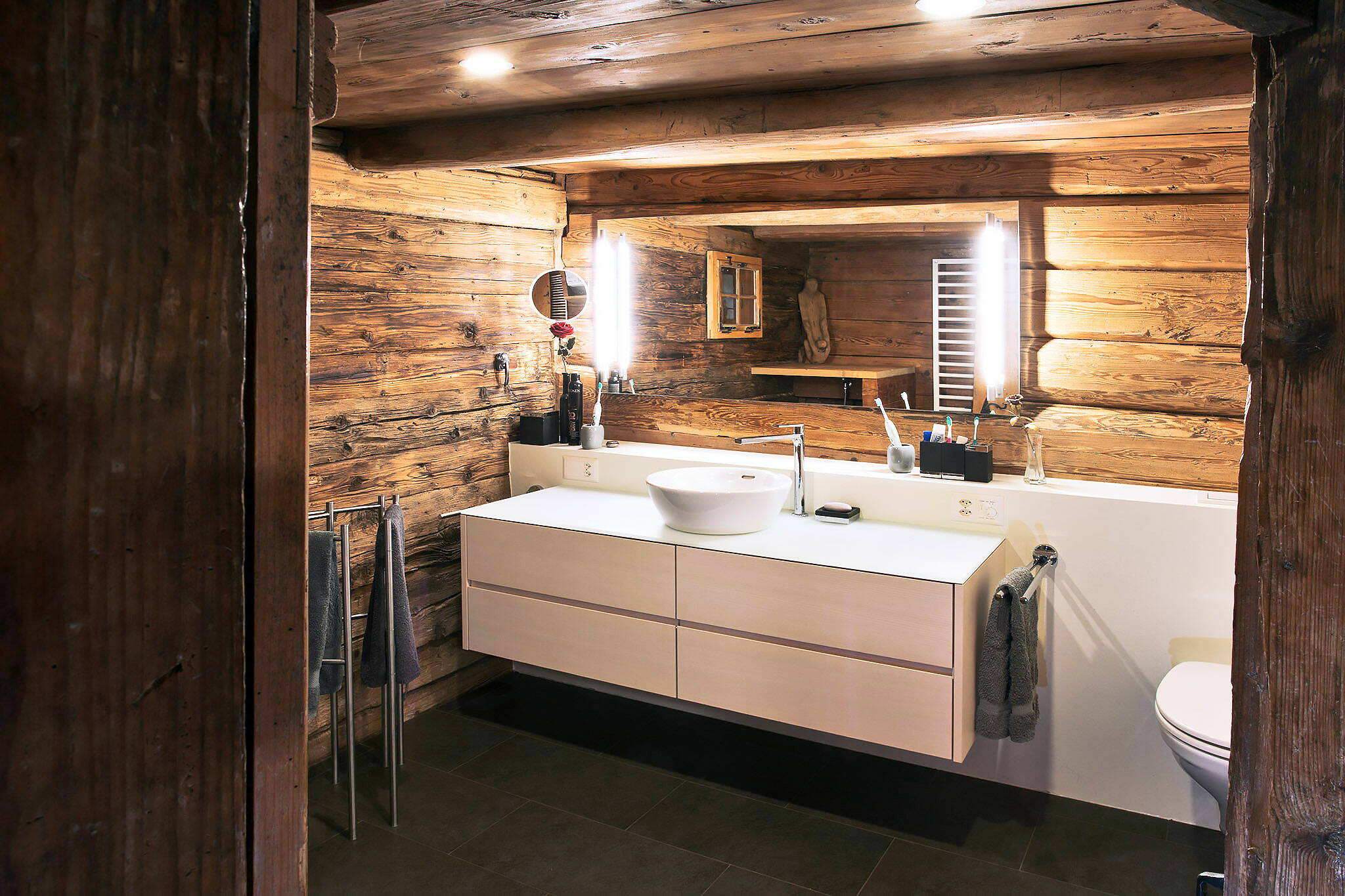 Zoom: Einsicht in ein Badezimmer mit alten Holzwänden und moderner Sanitärinstallation.