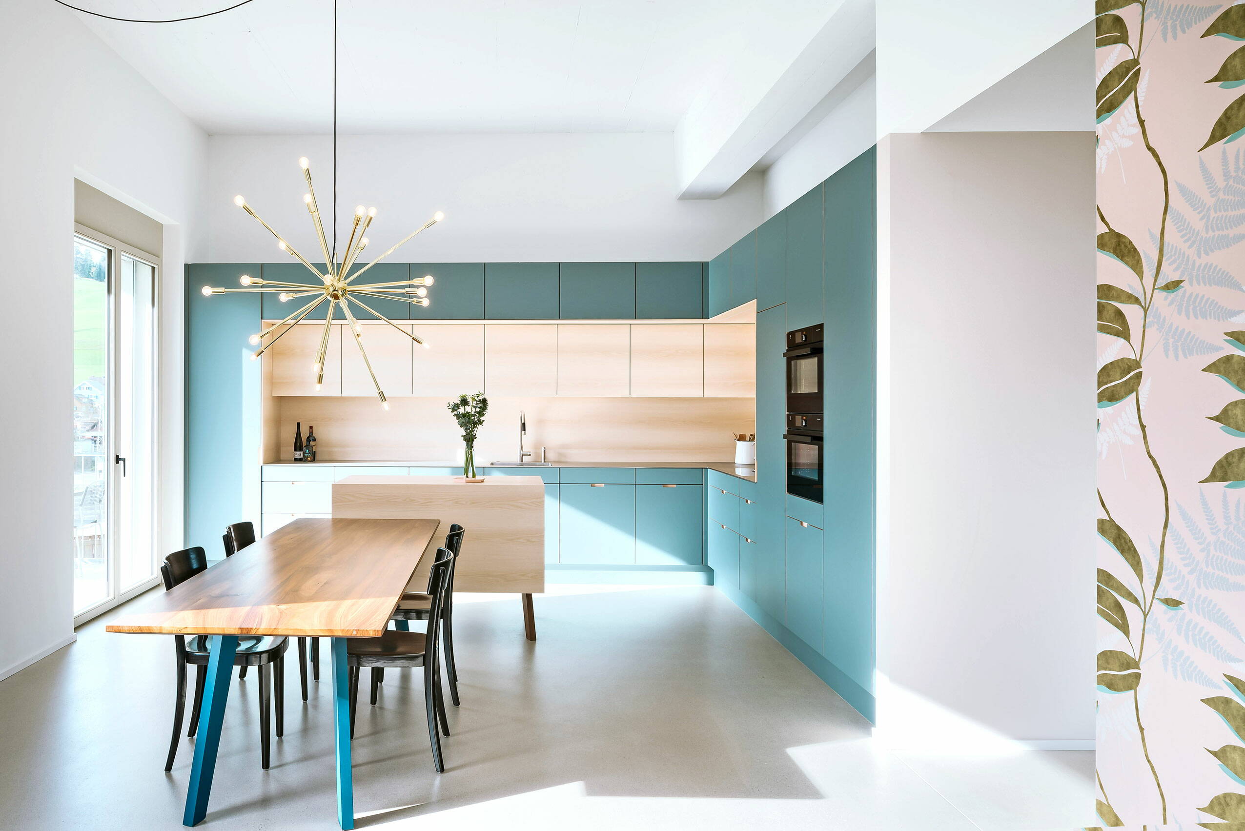 Zoom: Eine moderne Küche in einem Altbau mit schlichten Holzoberflächen und stimmigem Farbkonzept.
