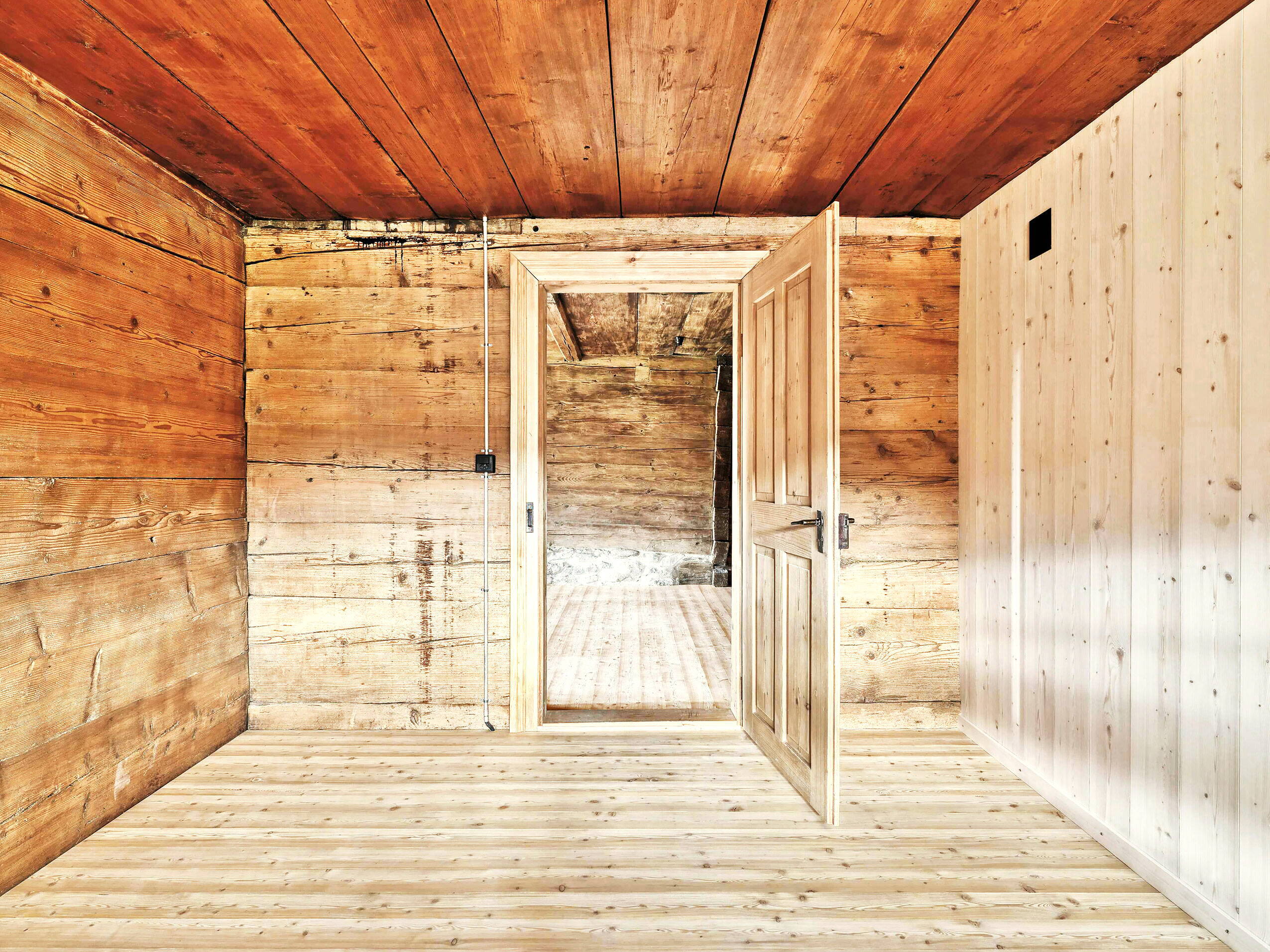 Sicht in einen Raum eines Altbaus der komplett aus Holz gefertigt ist.