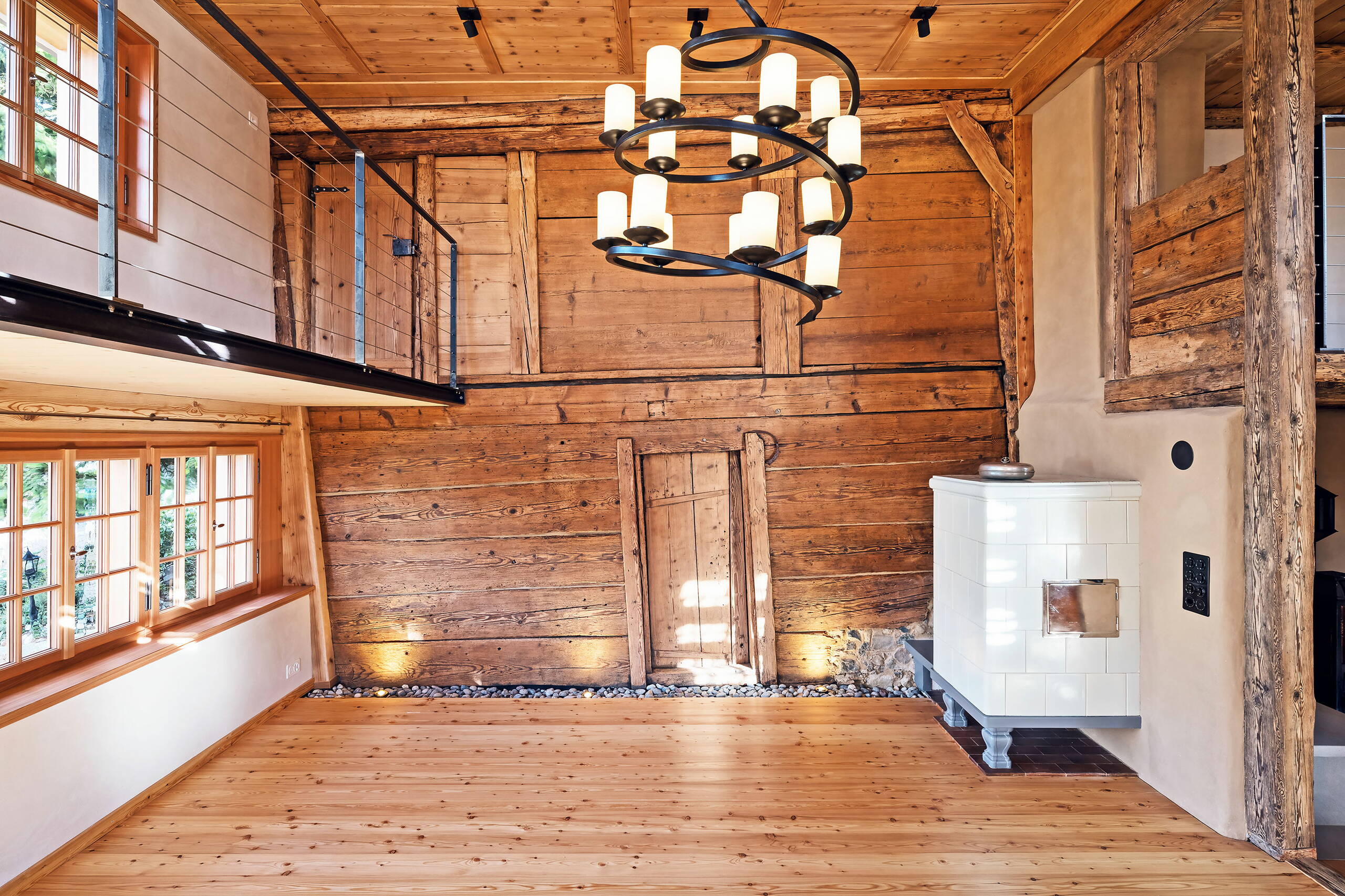 Das zweigeschossige Wohnzimmer mit freigelegter Holzbohlenständerwand (von 1449) und neu eingefügter Galerie.